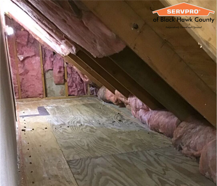 Low ceiling attic with walls removed and wooden frames are revealed.