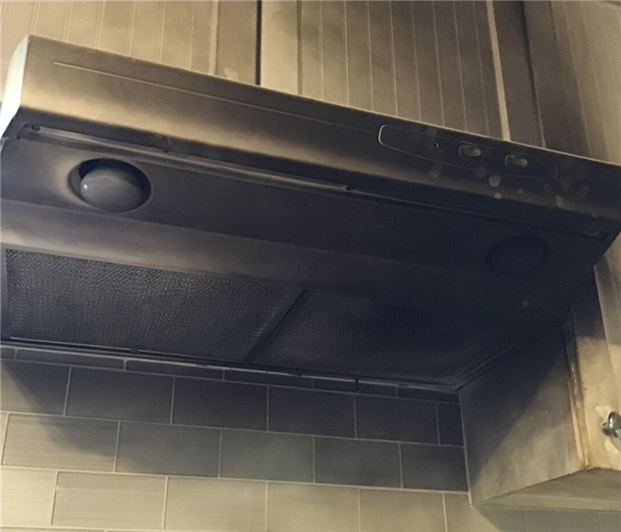 Close up of house kitchen vent covered in soot.