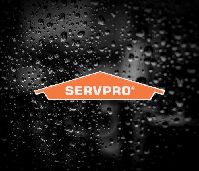 Black and white image of water droplets on a dark surface. Orange SERVPRO logo is in the foreground.